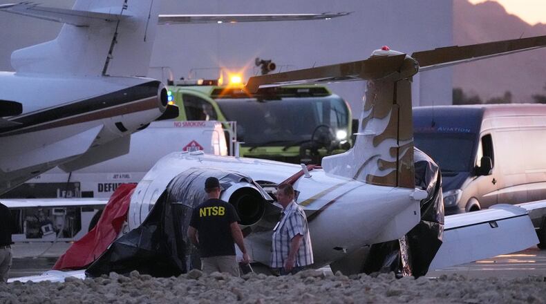 FILE - Investigators look at a crashed Learjet at Scottsdale Airport after it collided with a parked plane Feb. 10, 2025, in Scottsdale, Ariz. (AP Photo/Ross D. Franklin, File)
