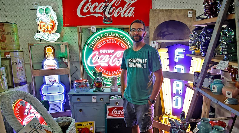 Russell Singleton is surrounded by neon in his booth at the Springfield Antique Show & Flea Market Extravaganza at the Clark County Fairgrounds Friday, Sept. 15, 2023. The Extravaganza runs through Sunday from 8:00 a.m. - 6:00pm and features over 2000 antique, vintage and flea market dealers. BILL LACKEY/STAFF