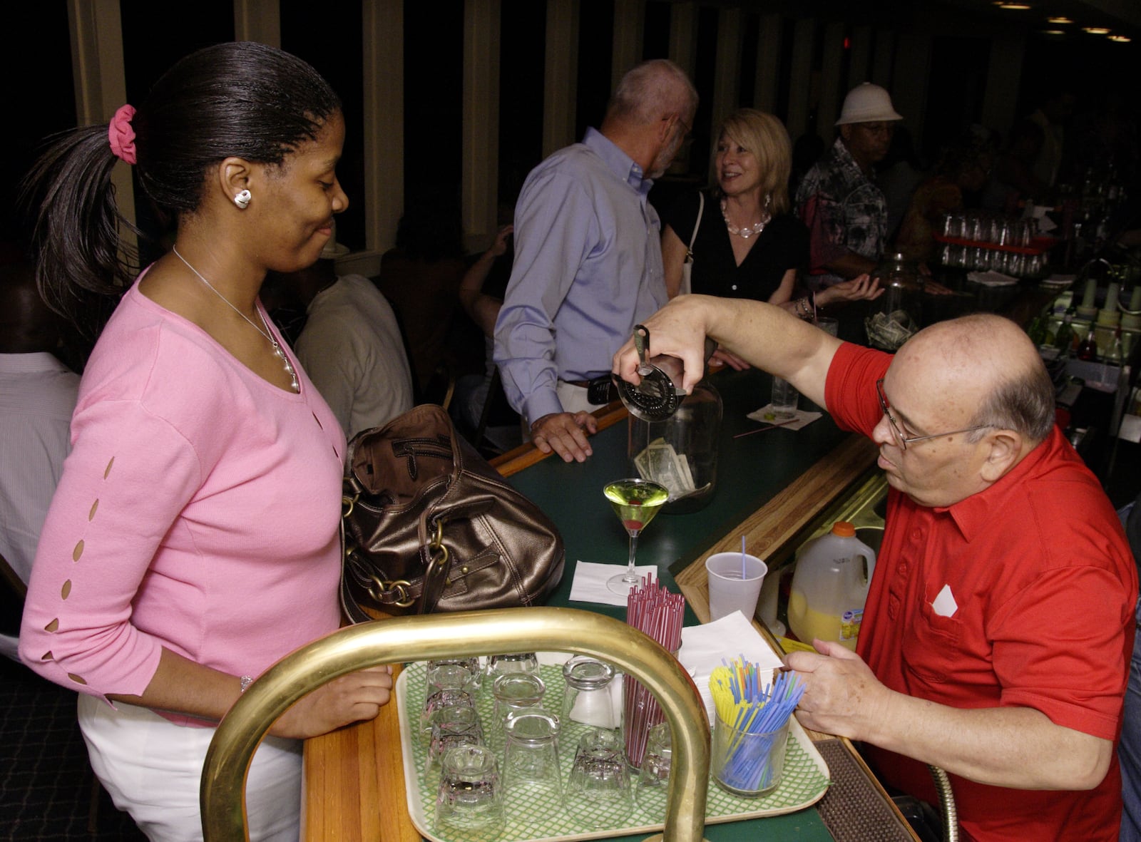 Kalene Gordon, from Dayton watches Jerry Gillotti pour a drink he made for her at Gilly's Niteclub in Dayton, Friday, May 11th.  When she got the drink, she said, "I hope this tastes as good as it looks."  Later, she confirmed that it did.  Behind them at the bar are Danny Bushong, from Kettering (left) and Nita Nordstrom, from the Oregon District.