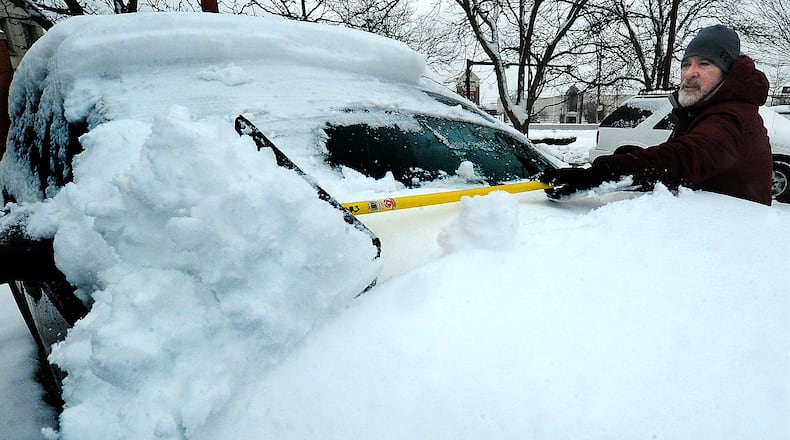 Michael Heil, the Used Car Inventory Manager for Matt Castrucci's Auto Mall of Dayton, removes snow from cars in the lot Monday Jan. 23, 2023. MARSHALL GORBY\STAFF