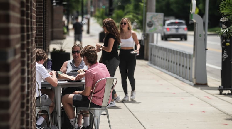 South Park Tavern cook Ivan Braatz sets up outdoor seating. JIM NOELKER/STAFF