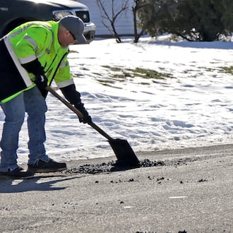 Tait Schnitzler, an employee of the City of Springfield, patches a pot hole along Superior Avenue Tuesday, Jan. 28, 2025. STAFF