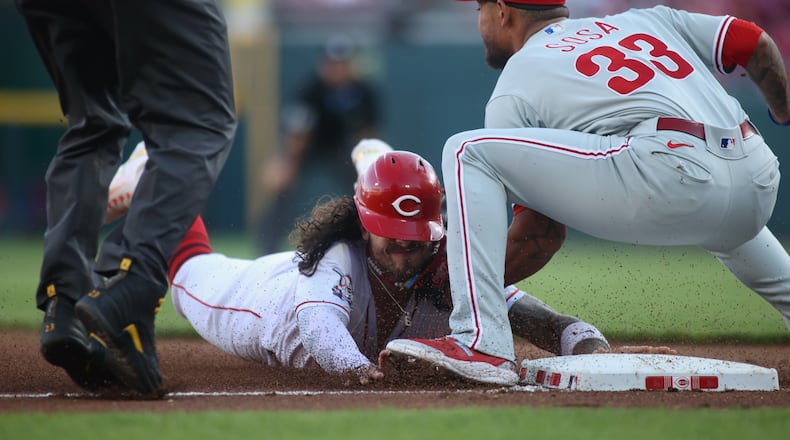 Jonathan India, of the Reds, slides into third against Edmundo Sosa, of the Phillies, on Thursday, April 13, 2023, at Great American Ball Park in Cincinnati. The throw from the catcher got past Sosa, and India scored. David Jablonski/Staff