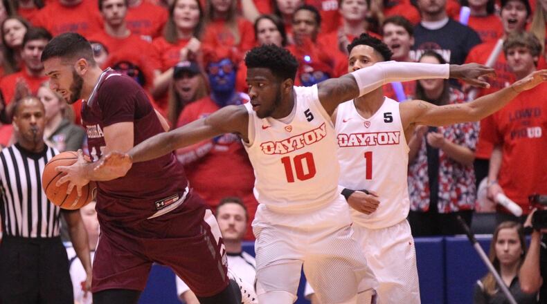 Fordham’s Joseph Chartouny, left, grabs a rebound against Dayton’s Jalen Crutcher on Saturday, Feb. 17, 2018, at UD Arena. David Jablonski/Staff