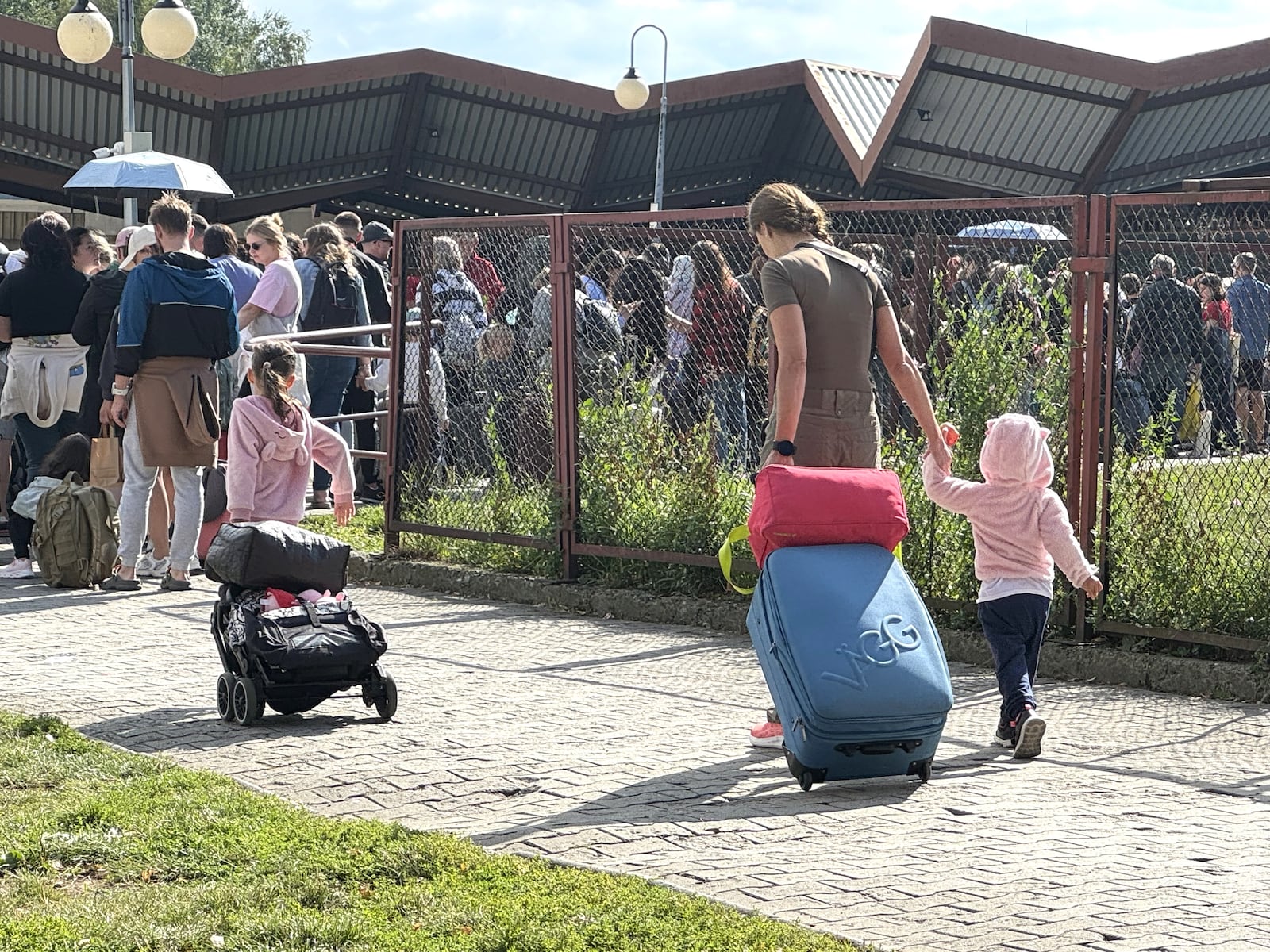 A Ukrainian mother and her two young daughters make their way to Poland’s Przemysl Glowny train station, which is 9.3 miles from the Ukrainian border. The family was headed back home to Ukraine. (Photo by Larry Connor)