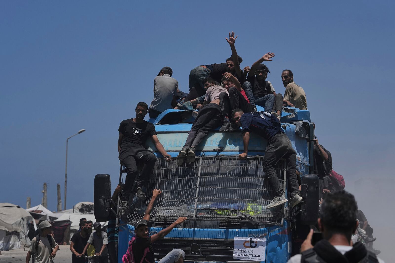 Palestinians hold onto an aid truck returning to Gaza City from the northern Gaza Strip on Tuesday, July 22, 2025. (AP Photo/Jehad Alshrafi)