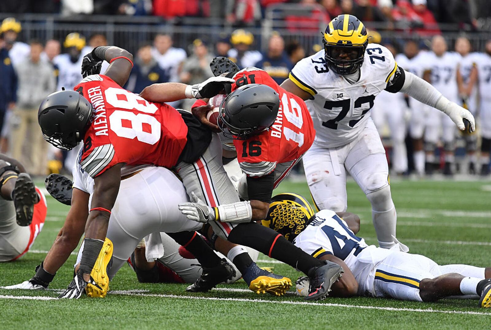 COLUMBUS, OH - NOVEMBER 26:   J.T. Barrett #16 of the Ohio State Buckeyes rushes for a first down during overtime of the game against the Michigan Wolverines at Ohio Stadium on November 26, 2016 in Columbus, Ohio.  (Photo by Jamie Sabau/Getty Images)