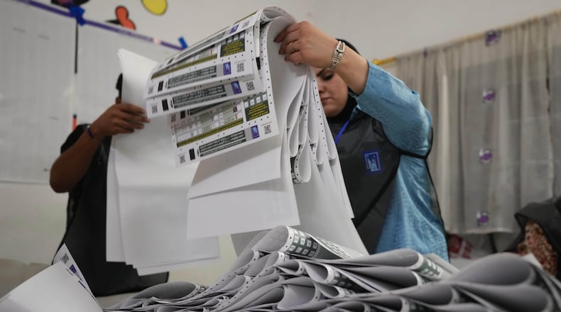 FILE - Election workers gather parliamentary election ballots after the polls closed in Baghdad, Iraq, Nov. 11, 2025. (AP Photo/Hadi Mizban, File)