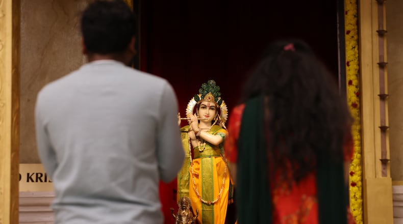Worshipers pray in front of a murti during a Diwali service at Hindu Temple of Dayton on Monday, Oct. 20 in Beavercreek. BRYANT BILLING/STAFF