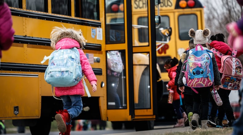 Students at Wright Brothers Elementary head to the bus for a ride home Tuesday December 13, 2022. Schools across the region are still struggling to cover bus routes including Huber Heights schools. JIM NOELKER/STAFF