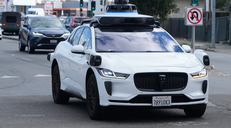 FILE - A Waymo vehicle drives past a No U-Turn sign in San Bruno, Calif., Tuesday, Sept. 30, 2025. (AP Photo/Jeff Chiu, File)