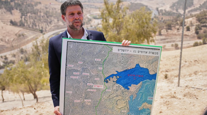 FILE - Israeli Finance Minister Bezalel Smotrich holds a map that shows the E1 settlement project during a press conference near the settlement of Maale Adumim, in the Israeli-occupied West Bank, Aug. 14, 2025. (AP Photo/Ohad Zwigenberg, File)