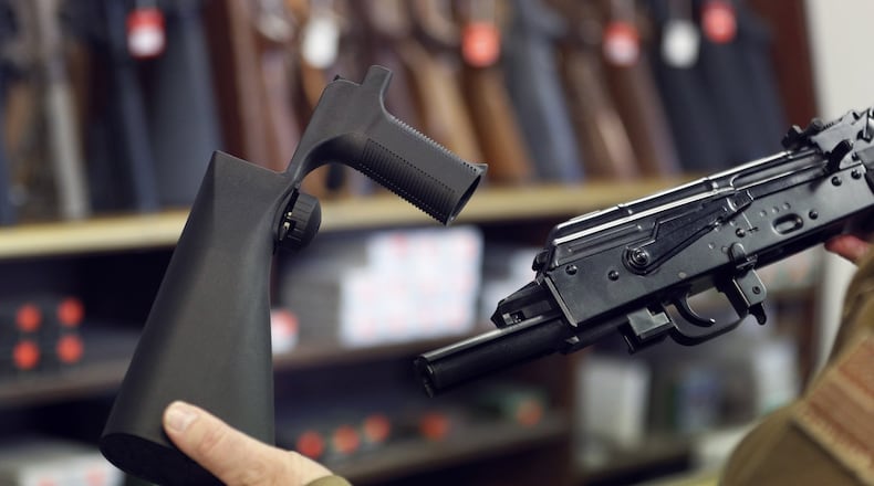A bump stock device (left), that fits on a semi-automatic rifle to increase the firing speed, making it similar to a fully automatic rifle, is shown next to a AK-47 semi-automatic rifle (right), at a gun store on Thursday in Salt Lake City, Utah. Congress is talking about banning this device after it was reported to of been used in the Las Vegas shootings on Sunday.