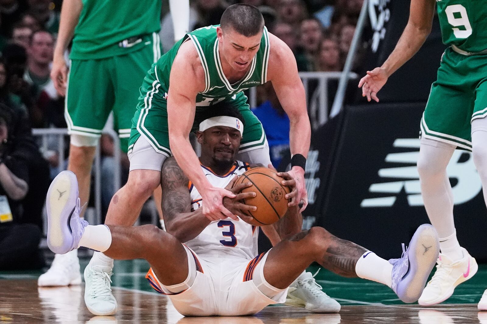 Phoenix Suns guard Bradley Beal (3) hangs onto the ball as Boston Celtics guard Payton Pritchard (11) tries for a steal during the first half of an NBA basketball game, Friday, April 4, 2025, in Boston. (AP Photo/Charles Krupa)