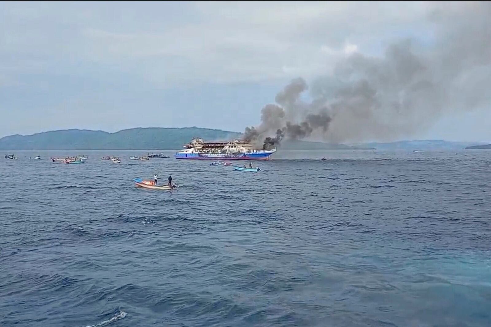 In this photo made from video released by the Indonesian National Search and Rescue Agency (BASARNAS), smoke billows from passenger ship KM Barcelona after it caught fire in the waters off Talise Island in North Sulawesi, Indonesia, Sunday, July 20, 2025. (BASARNAS via AP)