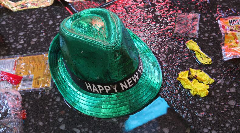 FILE - In this Jan. 1, 2019, file photo a "Happy New Year" hat lies on the wet ground along with other items following the celebration in New York's Times Square. Setting a New Year’s resolution about improving your finances is an excellent way to start 2021. But before you come up with a list of goals, be aware that there are a few you should avoid. (AP Photo/Tina Fineberg, File)