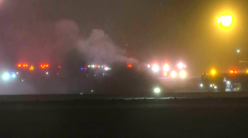 This image taken from video provided by WABI television, emergency services work on a scene of the Bombardier Challenger 600 crash at the Bangor Airport in Maine, late Sunday, Jan. 25, 2026. (WABI via AP)