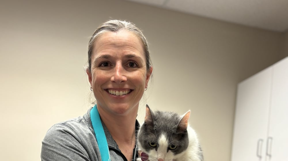 Dr. Jennifer Pue-Gilchrist, Pip's vet, gingerly holds a grumpy Pip who just had his yearly physical and his vaccinations updated. CONTRIBUTED