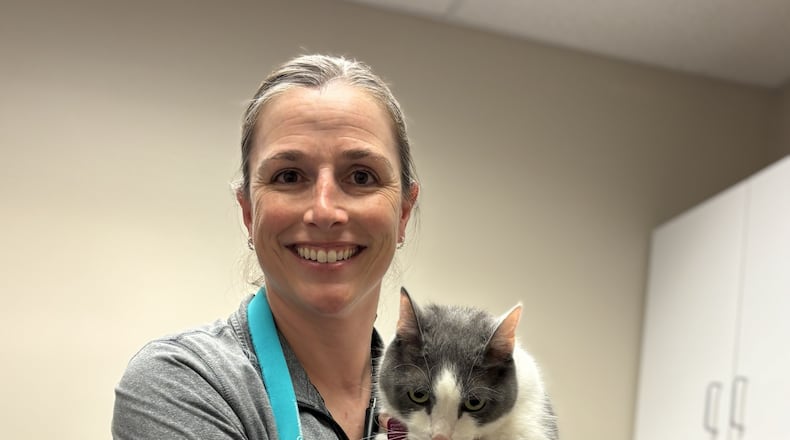 Dr. Jennifer Pue-Gilchrist, Pip's vet, gingerly holds a grumpy Pip who just had his yearly physical and his vaccinations updated. CONTRIBUTED