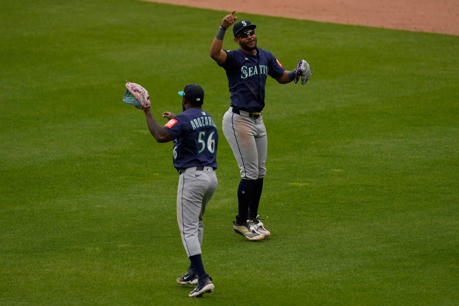 Seattle Mariners' Randy Arozarena, left, and Julio Rodríguez, right, celebrate after winning a baseball game against the Cincinnati Reds, Thursday, April 17, 2025, in Cincinnati. (AP Photo/Carolyn Kaster)