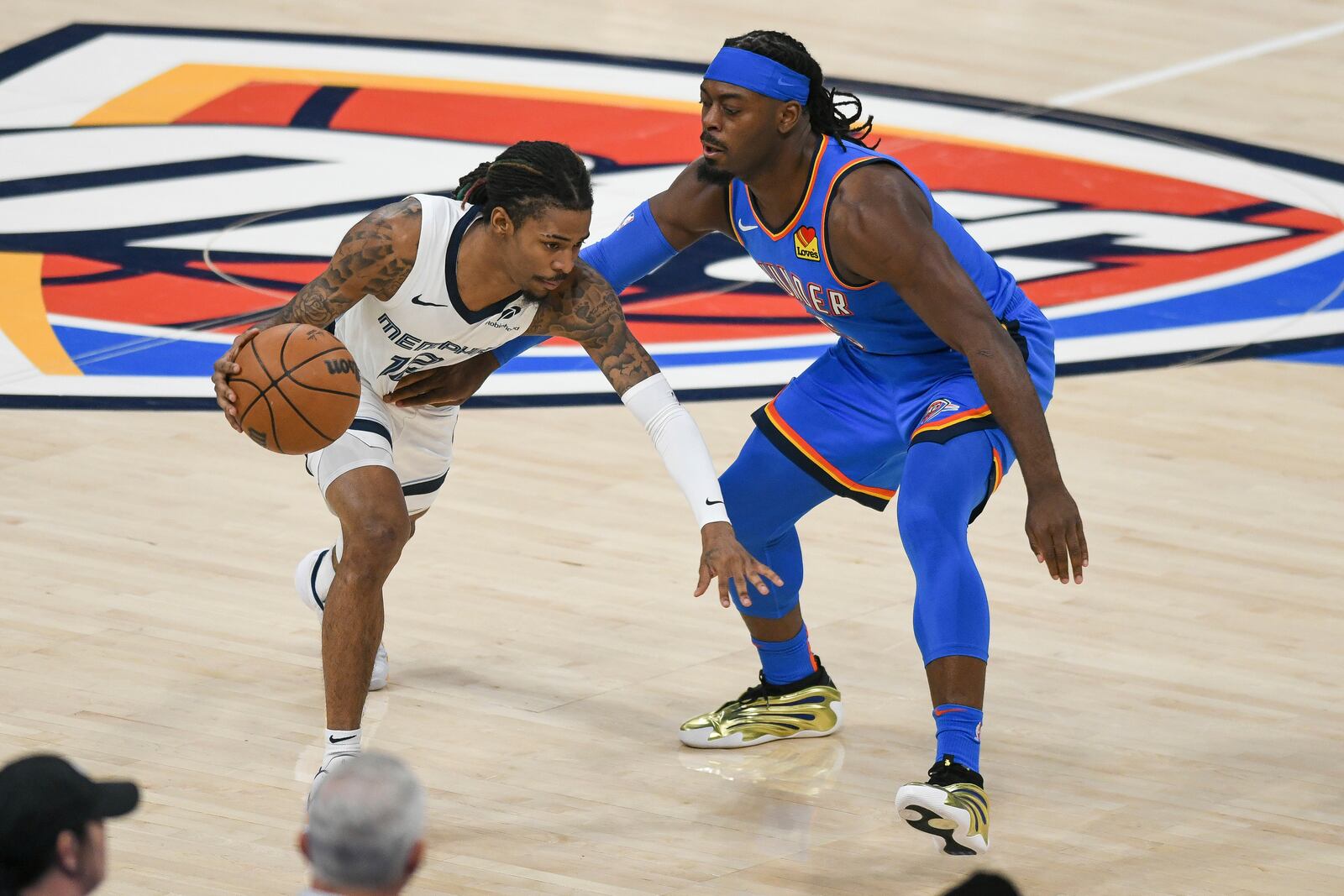 Memphis Grizzlies guard Ja Morant, left, drives past Oklahoma City Thunder guard Luguentz Dort, right, during the first half in Game 1 of an NBA first-round playoff series, Tuesday, April 22, 2025, in Oklahoma City. (AP Photo/Kyle Phillips)
