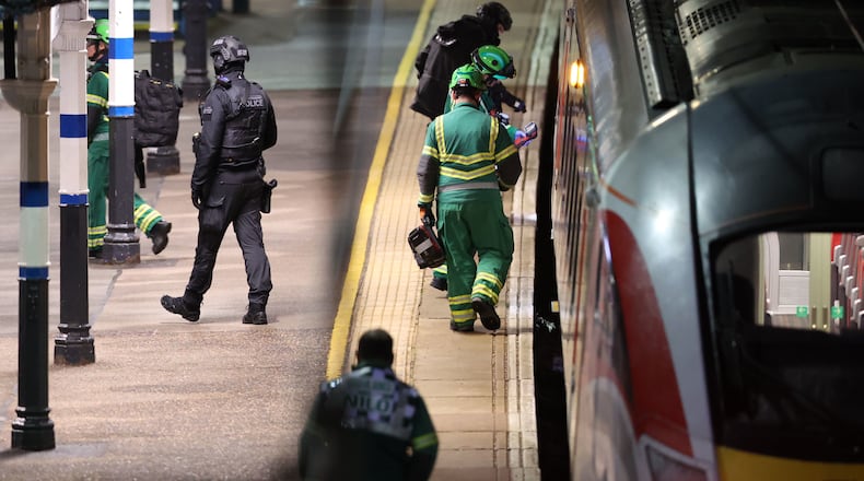 Emergency personnel inspect a train at the Huntingdon, England, train station in Cambridgeshire after people were stabbed Saturday, Nov. 1, 2025. (Chris Radburn/PA via AP)