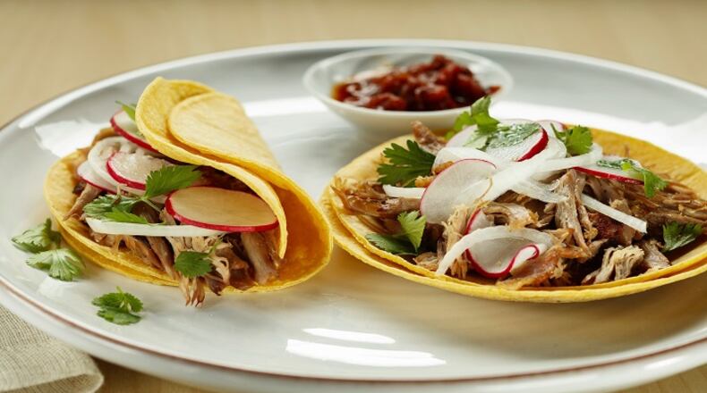 Radish, onion and cilantro top duck carnitas tacos, with the meat crisped up in a skillet after slow and low roasting. (Joan Moravek/food styling) (Chris Walker/Chicago Tribune/TNS)