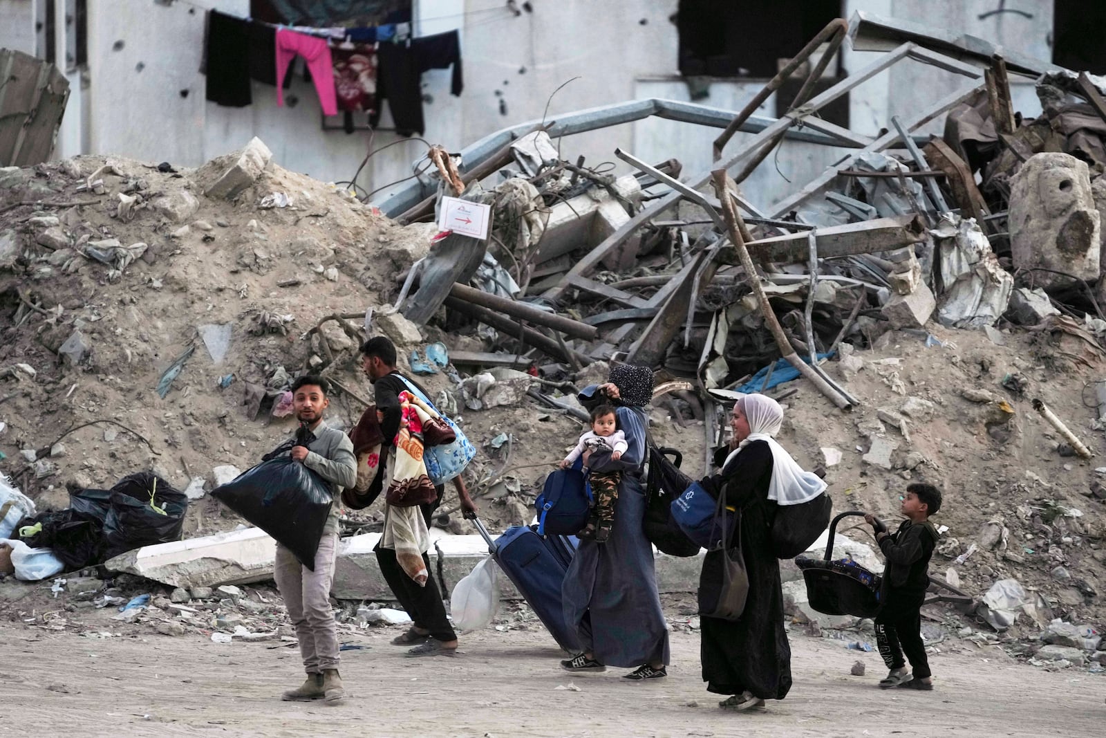 Palestinians evacuate after the Israeli army issued an evacuation warning for several schools and a hospital in Gaza City's Rimal neighborhood, Wednesday, May 14, 2025. (AP Photo/Jehad Alshrafi)
