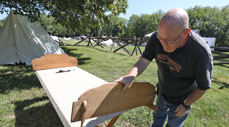 A member of the First Mad River Light Artillery makes his bed Thursday at their encampment as they get ready for The Fair at New Boston this weekend. BILL LACKEY/STAFF