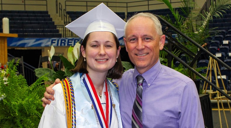 Carroll High School co-valedictorian Maria Schlegel celebrates her graduation with her father, Dave Schlegel, on May 18, 2018 at Trent Arena in Kettering. Maria followed in her father’s footsteps, as Dave was Carroll’s valedictorian 30 years earlier. CONTRIBUTED