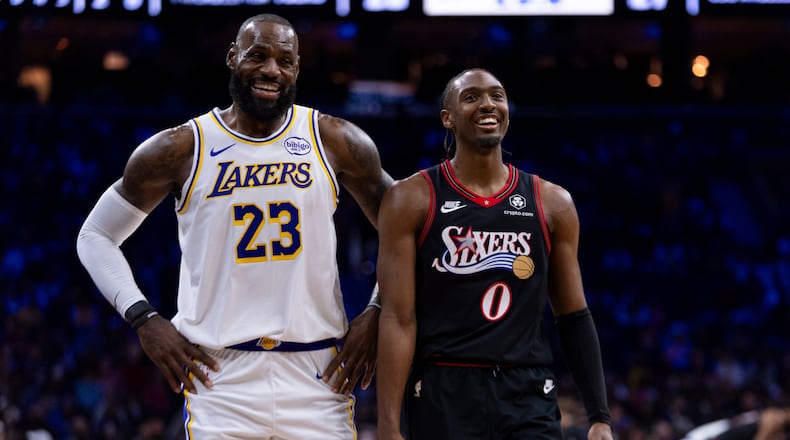 Los Angeles Lakers' LeBron James, left, talks with Philadelphia 76ers' Tyrese Maxey, right, during the first half of an NBA basketball game, Sunday, Dec. 7, 2025, in Philadelphia. (AP Photo/Chris Szagola)