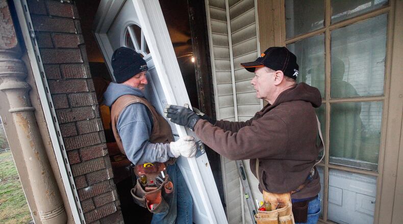 Matt McClellan, left, of Stewartville, Minn., helps install a door on a house in Old North Dayton damaged by Memorial Day tornadoes. McClellan is one of about 25 volunteers with the North American Lutheran Church that arrived in Dayton over the weekend to help rebuild tornado-damaged properties . CHRIS STEWART / STAFF