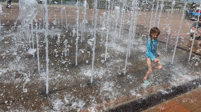 A young girl plays in the fountain at RiverScape MetroPark in downtown Dayton. CORNELIUS FROLIK / STAFF