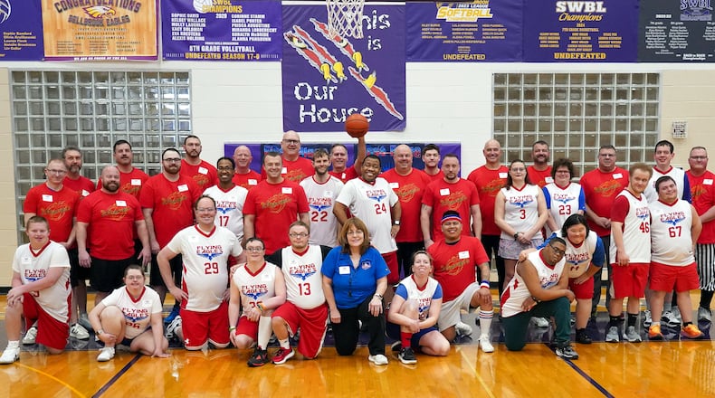 The Flying Eagles (in white) and the Extinguishers (in red) gathered for a group photo before their “Super Bowl” encounter on Monday, Feb. 23, 2026 at the Bellbrook Junior High gym. Gayle Horton, the director of Colin’s Lodge, whose members make up the Eagles, is in the center (in blue). Sugarcreek Township Fire Marshal Jordan Ewing who helped launch the idea of the game six years ago when he got together the Extinguishers, who are Sugarcreek Township and Bellbrook firefighters, EMS and police, is fifth from the left in row two. BELLBROOK LOCAL SCHOOLS / CONTRIBUTED PHOTO