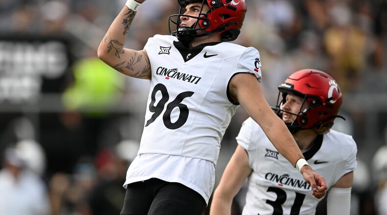 Cincinnati place-kicker Nathan Hawks (96) watches the flight of the ball with holder Mason Fletcher (31) after booting a field goal against Central Florida during the first half of an NCAA college football game, Saturday, Oct. 12, 2024, in Orlando, Fla. (AP Photo/Phelan M. Ebenhack)