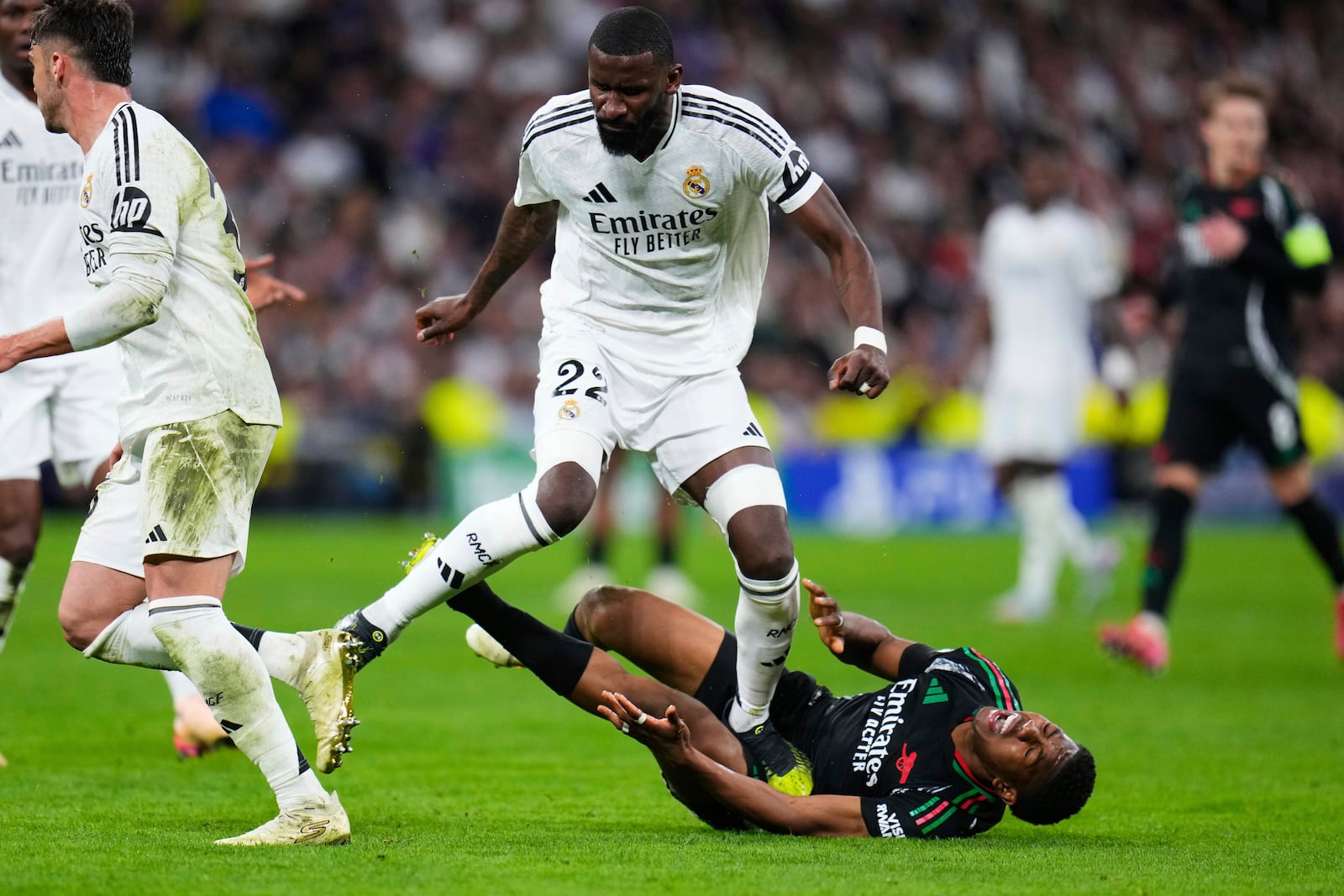 Real Madrid's Antonio Ruediger steps on Arsenal's Myles Lewis-Skelly, on the ground, during the Champions League quarterfinals second leg soccer match between Real Madrid and Arsenal at the Santiago Bernabeu stadium in Madrid, Wednesday, April 16, 2025. (AP Photo/Manu Fernandez)