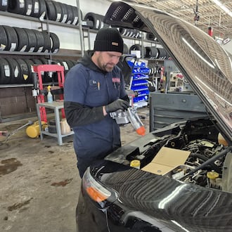 Rick Ahlers, a mechanic at Grismer Tire & Auto Service Center in Springboro, works on a faulty oil pump. Mechanics say storm-related business has been slower than expected. MICHAEL KURTZ / STAFF
