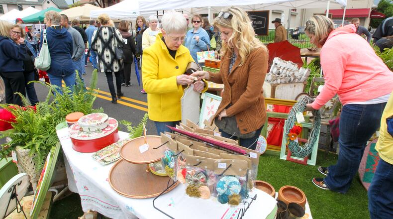 Lyndsay Rapier-Phipps of The Vintage Revival, center, talks with a customer during a 2016 Hamilton Flea. Hamilton’s “urban, modern-day flea market” kicks off its 2017 schedule on May 13 at the new Marcum Park. GREG LYNCH / STAFF