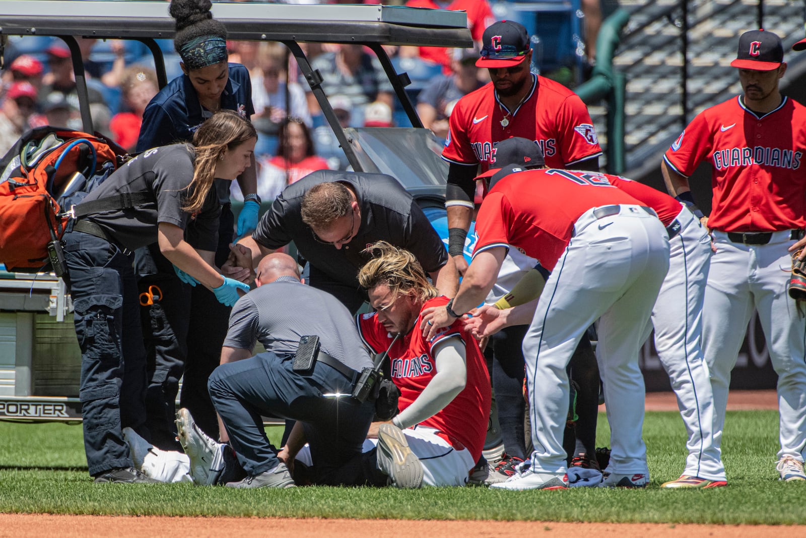 Cleveland Guardians' Gabriel Arias, sitting, is assisted after being injured during the third inning of a baseball game against the St. Louis Cardinals, Sunday, June 29, 2025, in Cleveland. (AP Photo/Phil Long)