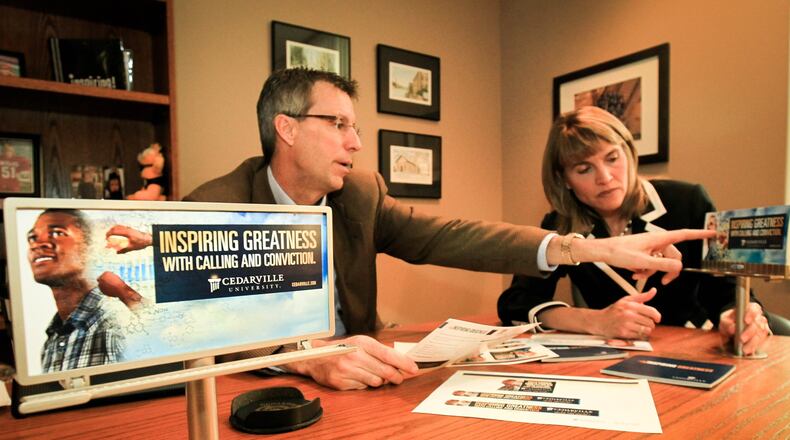 Cedarville University’s Mark Weinstein and Janice Supplee look over new campaign materials called “Calling and Conviction” that will be on billboards and other marketing materials. Colleges are spending big money to lure students in a competitive environment with a shrinking pool of students. Cedarville, a Christian college with about 3,400 students, will invest about $400K in a national ad campaign this year - money they say they have to spend so students will consider the school.