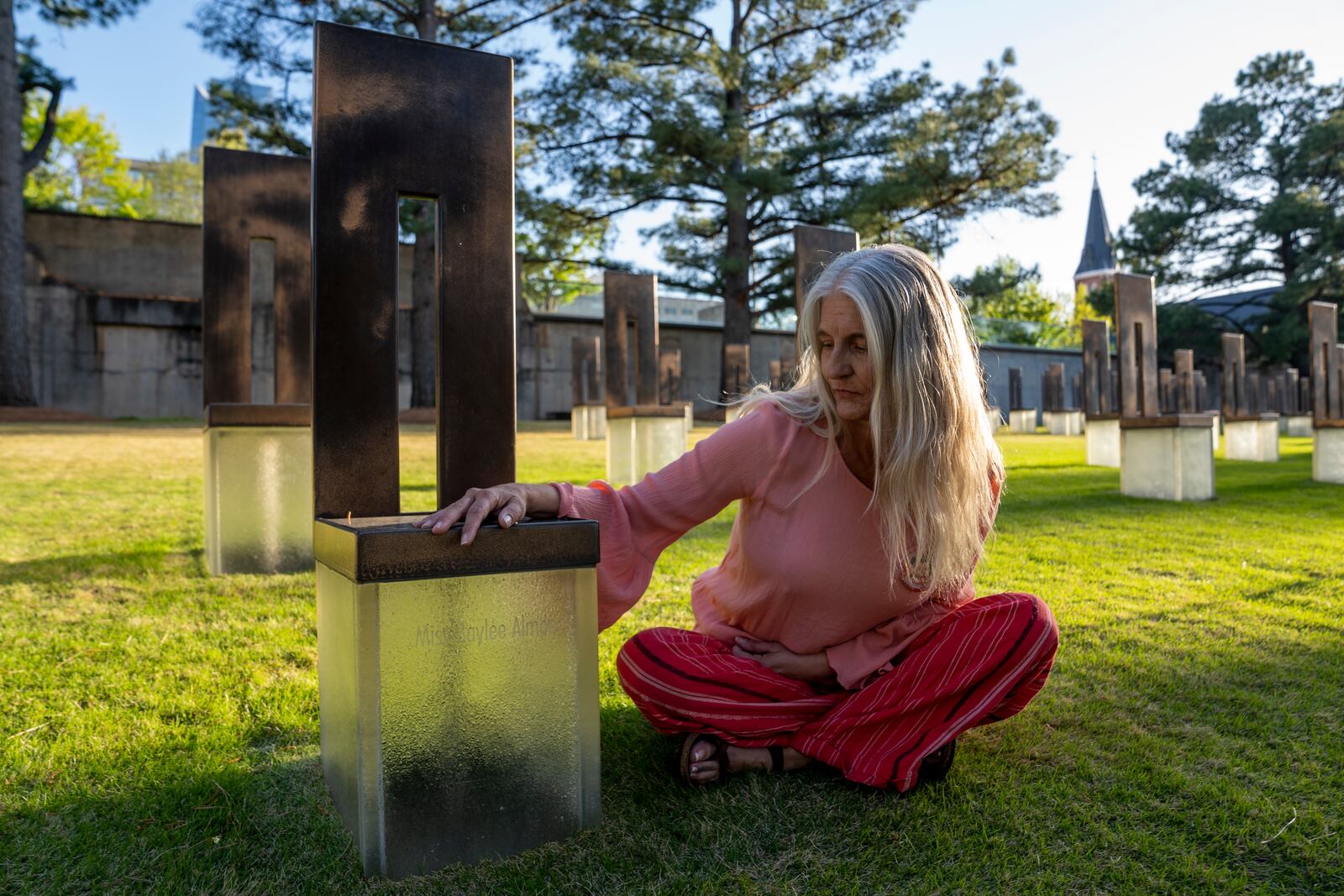 Aren Almon poses for a portrait next to the memorial chair for her daughter, Baylee Almon, at the Oklahoma City National Memorial on Wednesday, April 9, 2025 in Oklahoma City. (AP Photo/Nick Oxford)
