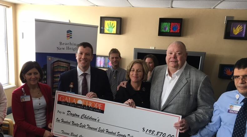 Gala of Hope Foundation founders Bob Mills and his wife, Barbara, presented an oversized novelty check for $198,870 to Dayton Children’s Hospital executives. Photo/ Randy Tucker