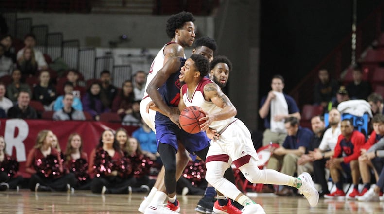Massachusetts’ Luwane Pipkins runs into Dayton’s Jalen Crutcher on Saturday, Feb. 3, 2018, at the Mullins Center in Amherst, Mass. David Jablonski/Staff