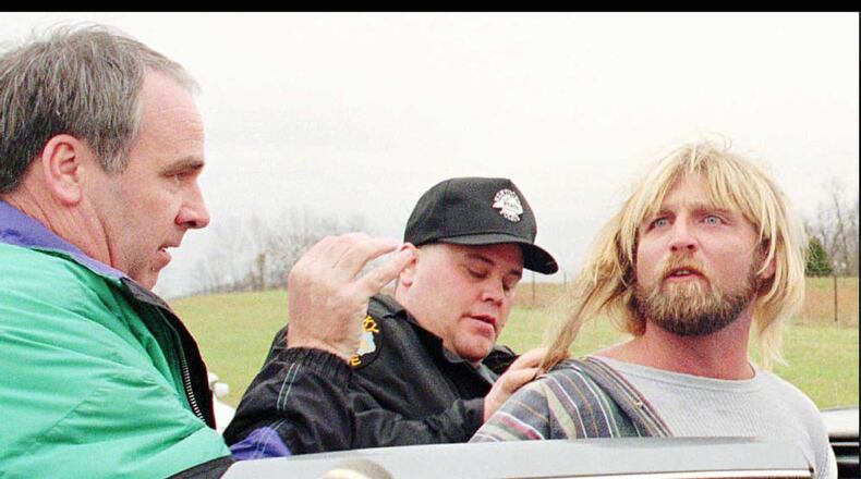 1995 FILE PHOTO: Bob Stephens, left, Kentucky state police detective, and another official put Glen Rogers in a police cruiser after Rogers was arrested Monday afternoon, Nov. 13, 1995, near rural Waco, Ky. Rogers, 33, is suspected of strangling or stabbing at least four women in California, Louisiana, Mississippi and Florida in the past two months. (AP Photo/The Richmond Register, Phil Poynter)
