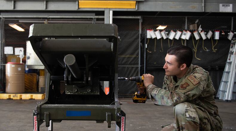 Senior Airman William Oskay, 96th Aircraft Maintenance Unit weapons load crew member, uses a power drill to test the capabilities of an ADU-468 as a part of the Project Arc program at Barksdale Air Force Base, Louisiana, Sept. 16, 2022. Project Arc is a program that consists of scientists and engineers from across the Air Force working with units to tackle problems and challenges using their knowledge to design new tools, widgets or rework a workflow. (U.S. Air Force photo by Staff Sgt. Christopher Tam)