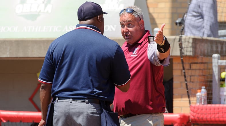 Lebanon coach Brian Kindell (right) argues with home-plate umpire Mike Burwell after Elyria scored the winning run in the bottom of the seventh inning of Saturday’s Division I state final at Firestone Stadium in Akron. CONTRIBUTED PHOTO BY BRYANT BILLING
