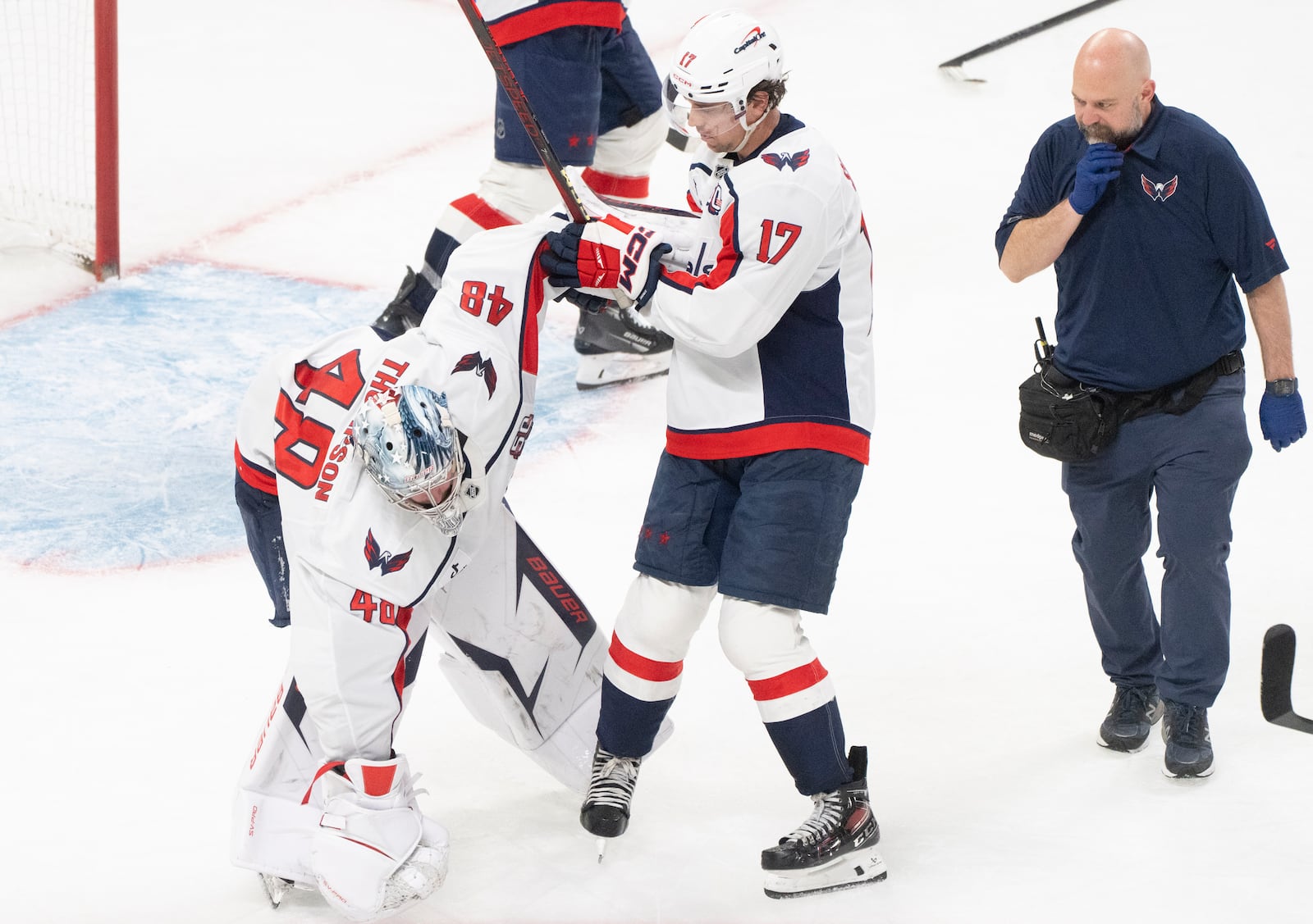 Washington Capitals goaltender Logan Thompson (48) stumbles as he is helped off the ice by teammate Dylan Strome (17) during the third period of Game 3 of a first-round NHL hockey playoff series against the Montreal Canadiens in Montreal, Friday, April 25, 2025. (Christinne Muschi/The Canadian Press via AP