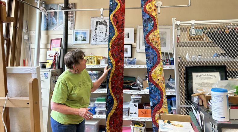 Collage artist Marsha Pippenger in her studio in the 1800′s Requarth Company Building. The metal pipes attached to the ceiling were once used for hanging blueprints. These artworks are for a 10-by 20-foot shipping container installation. Contributed