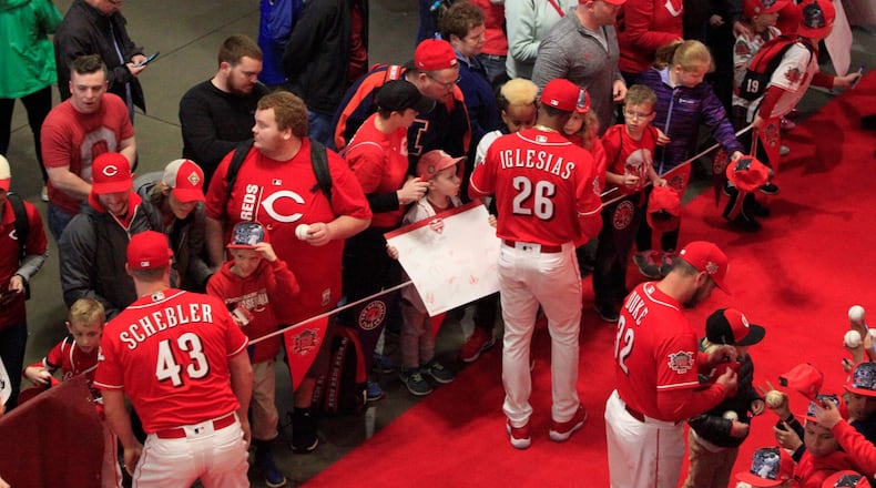 The Cincinnati Reds sign autographs as they walk the red carpet on Kids Day at Great American Ball Park on Saturday, March 30, 2019, in Cincinnati. David Jablonski/Staff