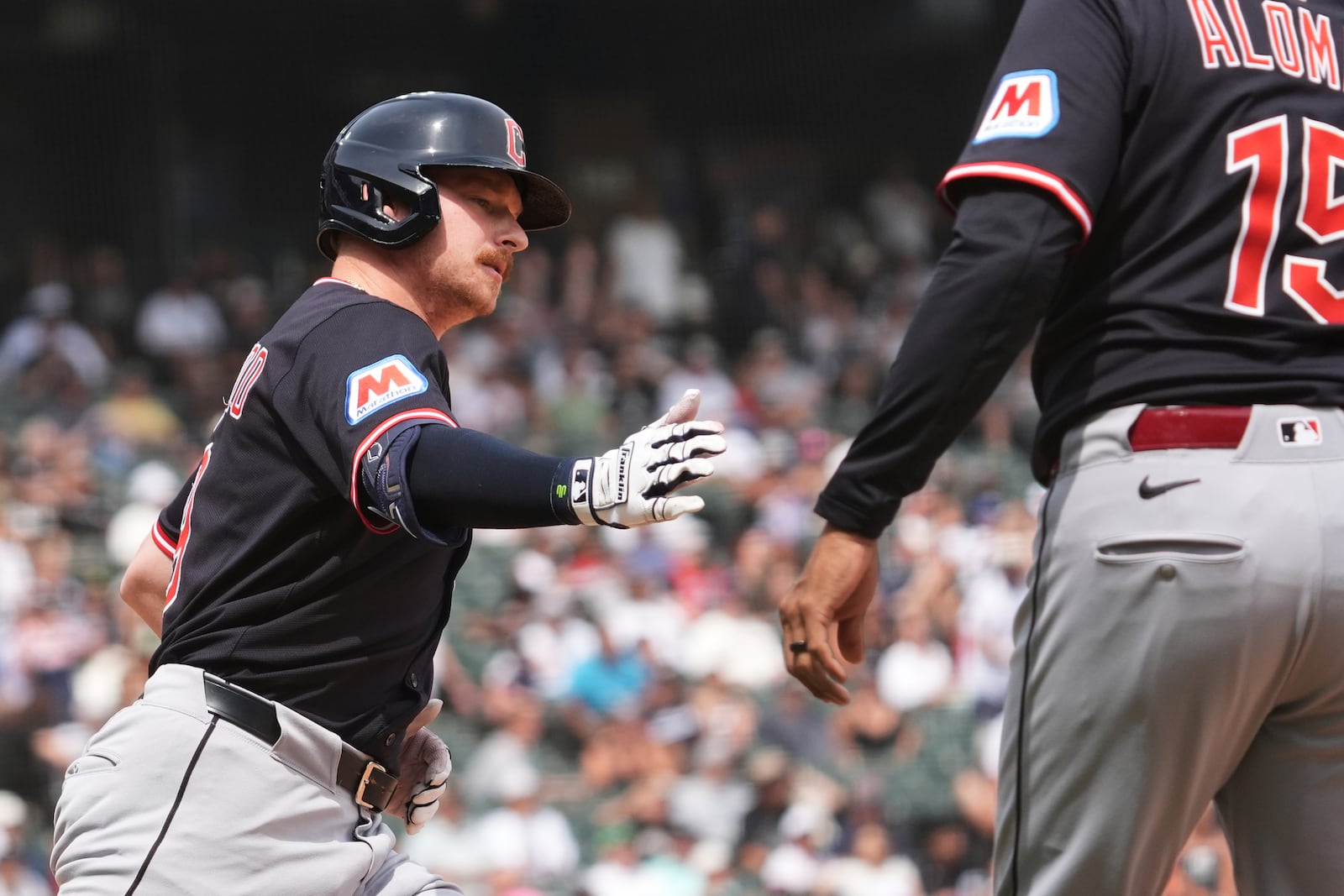 Cleveland Guardians' Kyle Manzardo, left, rounds the bases as he celebrates with first base coach Sandy Alomar Jr. after hitting a three-run home run during the sixth inning of a baseball game against the Chicago White Sox in Chicago, Sunday, July 13, 2025. (AP Photo/Nam Y. Huh)